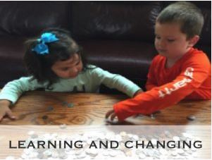 Photo of a toddler girl or left and her preschool aged brother on right playing with game pieces on a coffee table in front of the couch. Overlying text reads: Learning and Changing.