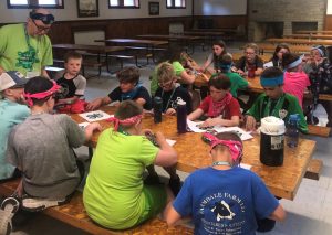 group of kids at summer camp, working at tables