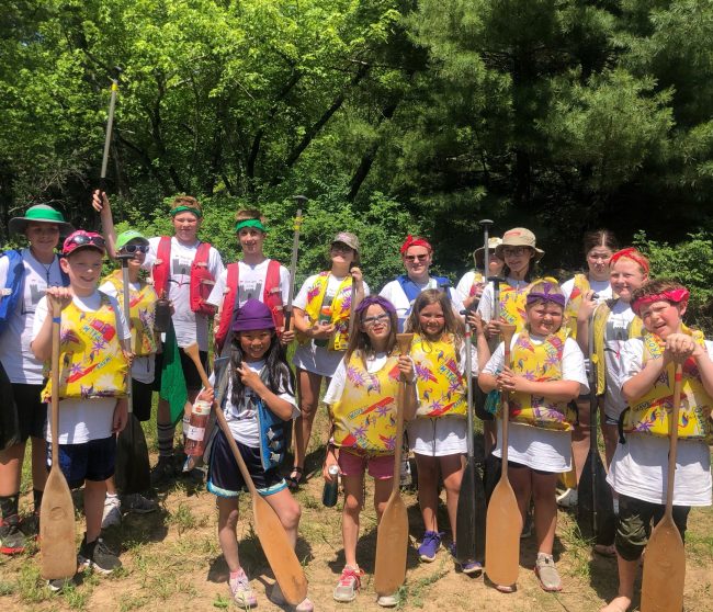 group of kids at summer camp with canoe paddles