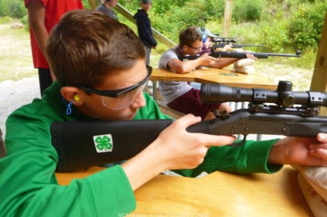 4-H youth learning to shoot a rifle
