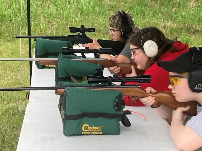 young people using rifle for target practice