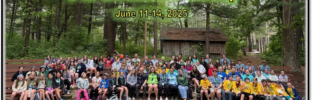 A large group of people, mostly children and teenagers, are seated on wooden benches in an outdoor setting surrounded by trees. They are posing for a group photo at the 2025 Washington County 4-H Summer Camp, which takes place from June 11-14, 2025. The text '2025 Washington County 4-H Summer Camp' and 'June 11-14, 2025' is prominently displayed at the top of the image in bright yellow letters. In the background, there is a rustic wooden cabin among tall trees. The foreground features a stone fire pit.