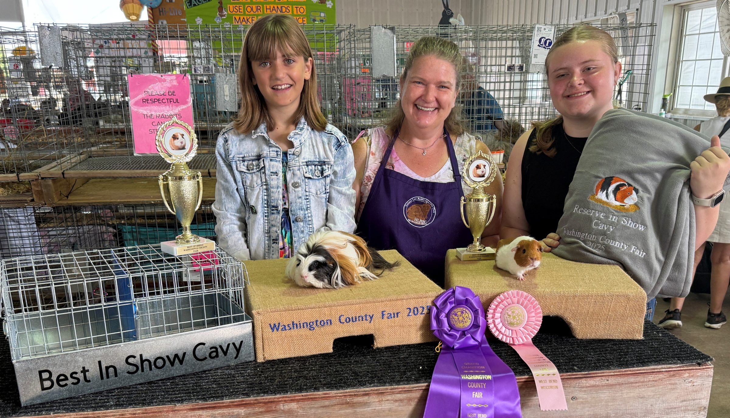 two 4-H youth with their prize winning cavies at the county fair, with the judge