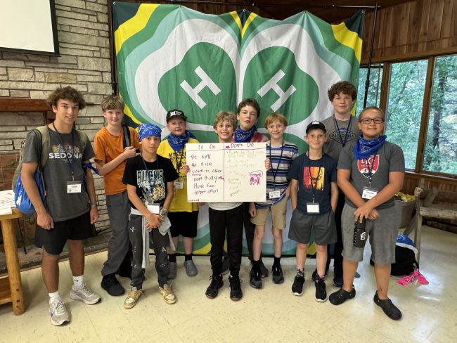 group of children in front of 4-H logo