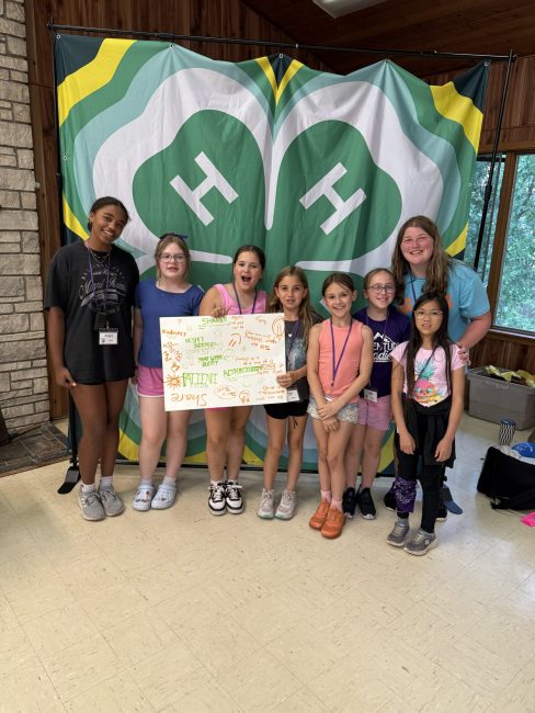 group of children in front of 4-H logo