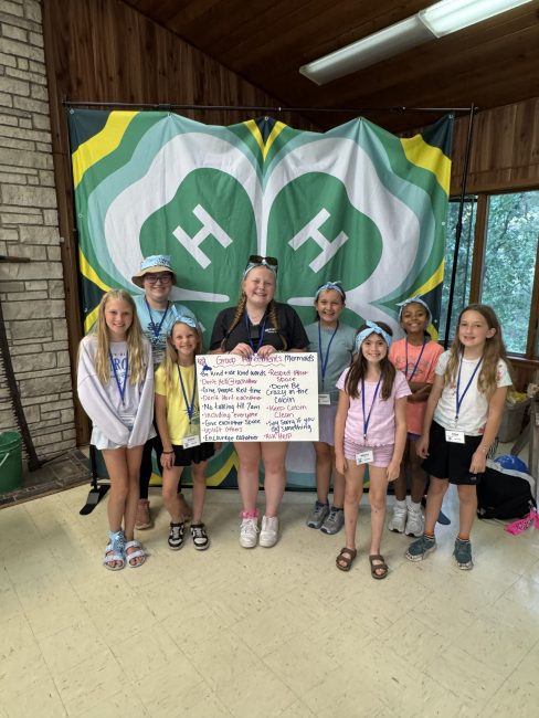 group of children in front of 4-H logo