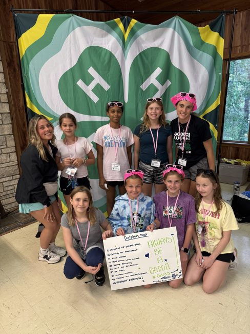 group of children in front of 4-H logo