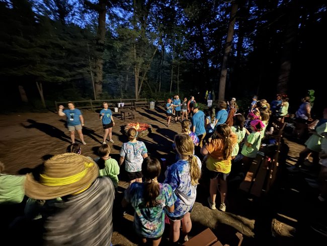 youth and adults around a campfire