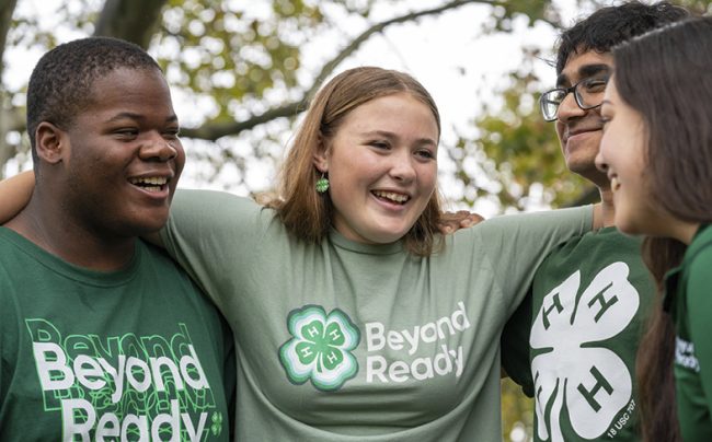 four children wearing clothing with 4-H logo